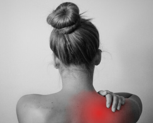 Bildlicher Fokus auf den Rücken, ein roter Schmerzpunkt signalisiert Rückenschmerzen.
